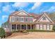 Attractive two-story house with a brick facade, inviting front porch, and well-maintained landscaping at 5810 Old Mill Trce, Lithonia, GA 30038