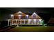 A grand home with exterior lighting, accentuating its architectural design and lush landscaping at twilight at 5810 Old Mill Trce, Lithonia, GA 30038