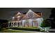 Home's front facade with manicured landscaping, lit up to highlight the home's beauty and design at 5810 Old Mill Trce, Lithonia, GA 30038