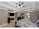 Main bedroom featuring tray ceilings, natural light, a seating area, and a television at 5810 Old Mill Trce, Lithonia, GA 30038