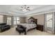 Main bedroom with tray ceilings, neutral decor, ample natural light, and a seating area at 5810 Old Mill Trce, Lithonia, GA 30038