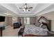 Large main bedroom with tray ceiling, accent chair and sitting area with television at 5810 Old Mill Trce, Lithonia, GA 30038