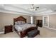 Spacious main bedroom featuring tray ceilings, ceiling fan, and dark wood furniture at 5810 Old Mill Trce, Lithonia, GA 30038