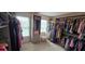 Large walk-in closet with custom storage solutions and an array of clothes at 5810 Old Mill Trce, Lithonia, GA 30038