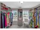 Spacious walk-in closet with custom shelving, many clothes, and a comfortable chair at 5810 Old Mill Trce, Lithonia, GA 30038