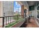 Balcony with wood-style flooring, black metal railing, greenery and a view of city buildings, sky and the outside at 845 Spring Nw St # Ph 5, Atlanta, GA 30308