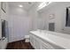 Bathroom with a single sink vanity with large mirror, and shower tub combo with white shower curtain at 845 Spring Nw St # Ph 5, Atlanta, GA 30308