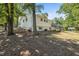Expansive backyard showing the home's back elevation, patio, and a backdrop of mature trees at 4890 Old Briar Trl, Douglasville, GA 30135