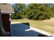 Fenced backyard featuring a large concrete patio and mature trees at 893 Andrews Dr, Conyers, GA 30012