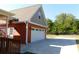 Two-car garage with white door, accented by exterior lighting and a wide driveway at 893 Andrews Dr, Conyers, GA 30012