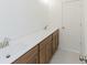 Bathroom with double sink, brown cabinets, light tile, and walk-in shower at 6545 Rhett Run, Cumming, GA 30028