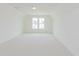 Bright, carpeted bedroom featuring large windows and neutral decor at 6545 Rhett Run, Cumming, GA 30028