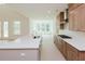 Bright kitchen features a large island and sink with stainless steel appliances and wood cabinets at 6545 Rhett Run, Cumming, GA 30028