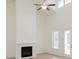 Bright living room with a fireplace, ceiling fan, tall ceilings, and large windows at 6545 Rhett Run, Cumming, GA 30028