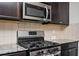 Close-up of the kitchen showcasing the stove, microwave, and granite countertop at 149 Woodhouse Cir, Acworth, GA 30102