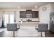 Open-concept kitchen featuring a breakfast bar, dark cabinetry, and modern lighting fixtures at 149 Woodhouse Cir, Acworth, GA 30102