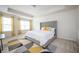 Spacious main bedroom featuring a tufted headboard, tray ceiling, and natural light at 149 Woodhouse Cir, Acworth, GA 30102