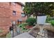 Brick building, mature tree, short retaining wall, and wrought iron details with a sidewalk at 330 3Rd St # Apt 1, Atlanta, GA 30308