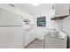 Compact kitchen features white cabinetry, appliances, a window offering ample natural light, and gray floors at 330 3Rd St # Apt 1, Atlanta, GA 30308