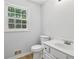 Clean white bathroom with modern sink and toilet near a window with natural light at 56 Carlane Cir, Bowdon, GA 30108