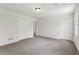 Bright carpeted bedroom with double closets, access to another room, and overhead lighting at 56 Carlane Cir, Bowdon, GA 30108