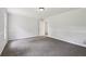 Bright bedroom with gray carpet, neutral walls, white trim, and entry to another room at 56 Carlane Cir, Bowdon, GA 30108