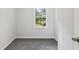 Small bedroom with gray carpet, window, paneled walls, and access to a hallway at 56 Carlane Cir, Bowdon, GA 30108
