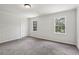 Carpeted bedroom with paneled walls, bright natural light through the window, and overhead lighting at 56 Carlane Cir, Bowdon, GA 30108