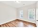 This bedroom features hardwood floors, neutral paint, and two windows for natural light at 1530 Avalon Creek Rd, Sugar Hill, GA 30518