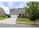 Inviting two-story home featuring manicured lawn, attached two-car garage, and covered front porch at 1530 Avalon Creek Rd, Sugar Hill, GA 30518