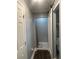 Hallway view of bathroom with shower, gray walls, dark floors, and white trim at 2225 Baker Nw Ter, Atlanta, GA 30318
