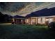 Beautiful backyard at dusk, featuring a manicured lawn and a cozy covered patio at 3468 Aberrone Pl, Buford, GA 30519