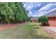 Spacious backyard featuring mature trees, lush lawn, and brick walkway leading to the home's exterior at 3468 Aberrone Pl, Buford, GA 30519