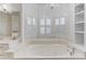 Bright Primary bath featuring large soaking tub, shuttered windows, double sinks, and vanity at 3468 Aberrone Pl, Buford, GA 30519