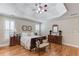 Classic bedroom featuring tray ceilings, hardwood floors, shuttered windows, and matching dressers at 3468 Aberrone Pl, Buford, GA 30519