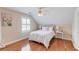 Cozy bedroom with hardwood floors, neutral walls, a window with blinds, and a comfortable bed at 3468 Aberrone Pl, Buford, GA 30519