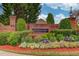 Elegant community entrance with brick signage, lush landscaping, and colorful flowerbeds at 3468 Aberrone Pl, Buford, GA 30519