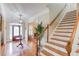 Welcoming foyer with hardwood floors, staircase, decorative rug, and a stylish front door at 3468 Aberrone Pl, Buford, GA 30519
