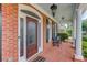 Charming brick front porch with decorative glass door and exterior bench seating at 3468 Aberrone Pl, Buford, GA 30519