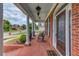 Charming front porch with brick flooring, white columns and an inviting seating area at 3468 Aberrone Pl, Buford, GA 30519
