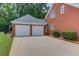 Home exterior featuring a lit, attached two-car garage and driveway at 3468 Aberrone Pl, Buford, GA 30519