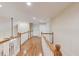 Upstairs hallway showcasing wood floors, white railing, and built-in cabinets at 3468 Aberrone Pl, Buford, GA 30519