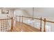 Hallway with wood flooring, white railings, and views down to the living area at 3468 Aberrone Pl, Buford, GA 30519