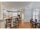 Open concept kitchen and dining area with white cabinetry, granite countertops, and hardwood floors at 3468 Aberrone Pl, Buford, GA 30519