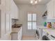 Functional laundry room with granite countertops, a sink, window and modern washer and dryer units at 3468 Aberrone Pl, Buford, GA 30519