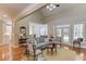 Bright living room with hardwood floors, light blue sofa, french doors, and views into the breakfast room at 3468 Aberrone Pl, Buford, GA 30519