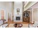 Elegant living room with hardwood floors, fireplace, high ceilings, and built-in features at 3468 Aberrone Pl, Buford, GA 30519