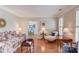 Bright living room with hardwood floors, white shutters, and comfortable seating arrangement at 3468 Aberrone Pl, Buford, GA 30519