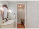 Vintage powder room featuring decorative wallpaper, decorative mirror, sconces and pedestal sink at 3468 Aberrone Pl, Buford, GA 30519