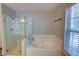 Bathroom featuring a glass-enclosed shower, soaking tub, and modern fixtures at 4149 Spring Cove Dr, Duluth, GA 30097